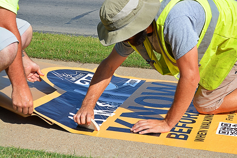 Workers preparing a sign for installation.